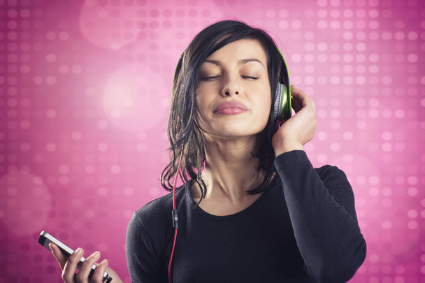 Happy calm girl enjoying listening to music with earphones. - Foto, afbeelding