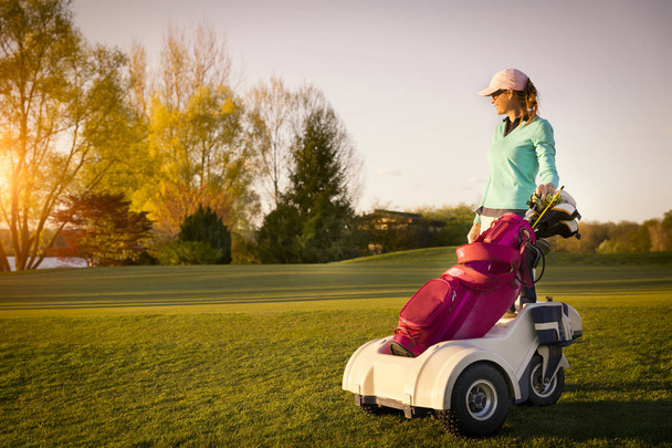 Female golf player with golf bag. - Zdjęcie, obraz