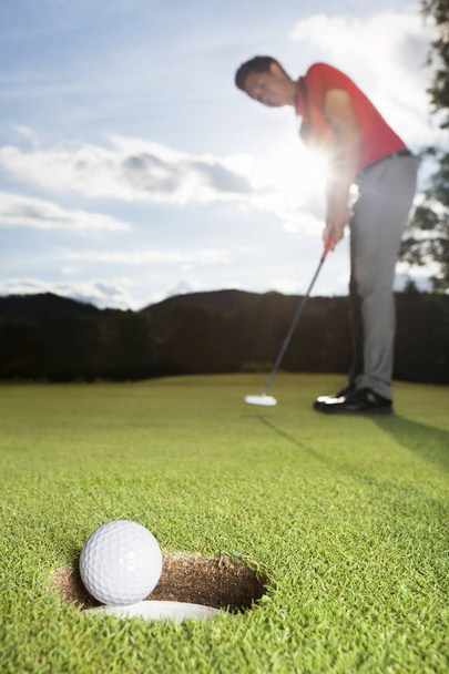 Golfer putting ball into cup. - Photo, image