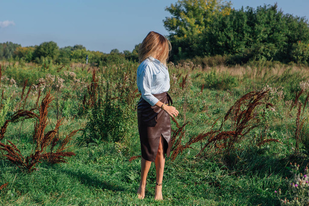 Happy young beautiful woman walking in a green field - Valokuva, kuva