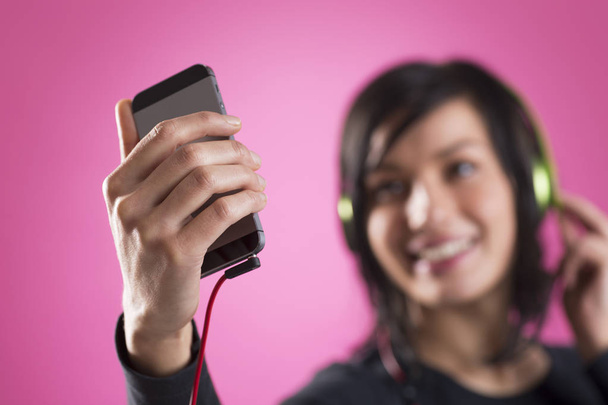 Joyful girl listening to music with earphones and m3p player. - Foto, Imagen