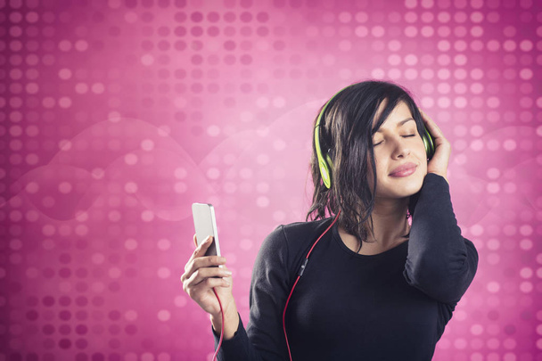 Joyous calm girl enjoying listening to music with headphones. - Fotoğraf, Görsel