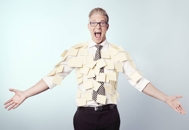 Frustrated businessman covered by blank post-it notes. - Foto, Imagen