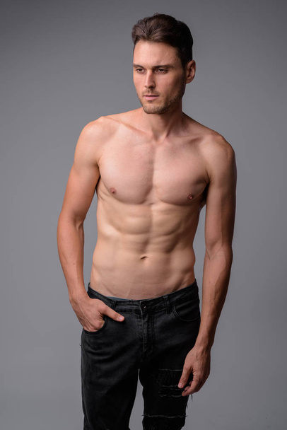 Studioaufnahme eines gut aussehenden, muskulösen Mannes ohne Hemd - Foto, Bild