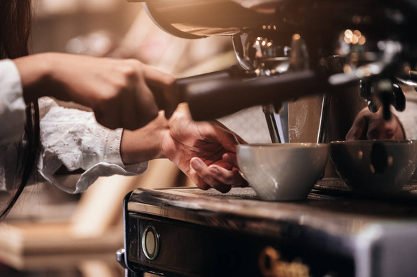 Closeup of professional female barista hand making cup of coffee - Foto, Imagen