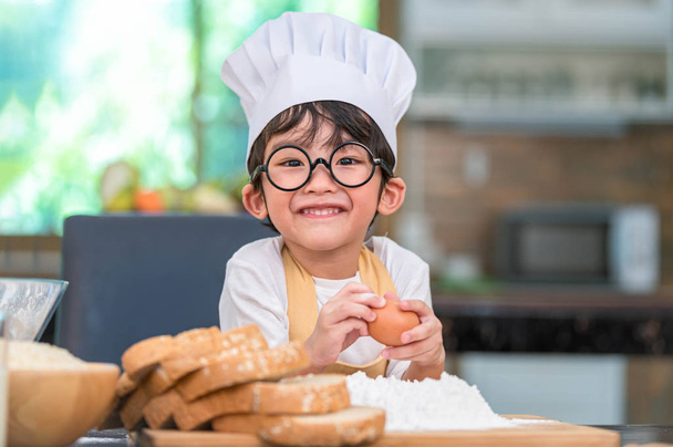 Portrait cute little Asian happy boy interested in cooking funny - Photo, Image