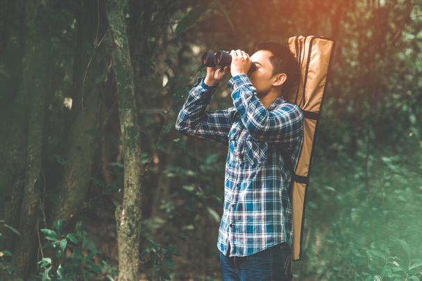 Mann mit Fernglas-Teleskop im Wald sucht Ziel als l - Foto, Bild