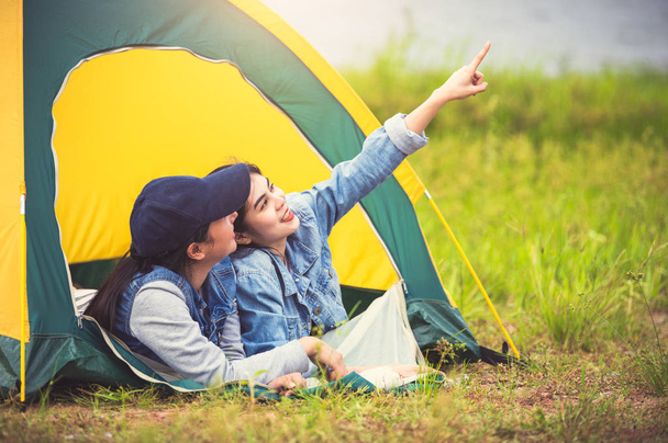 Kaksi läheinen ystävä Aasian ystävyys rentoutua camping teltta vihreä
 - Valokuva, kuva