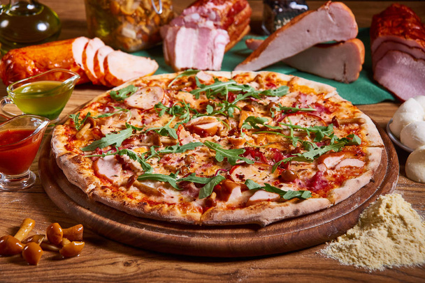 Pyszna włoska pizza serwowana na drewnianym stole. Pizza w plasterkach. smaczny skład pizzy - Zdjęcie, obraz