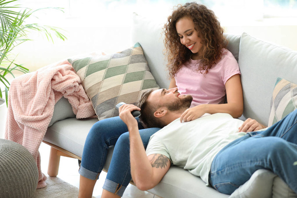 Счастливая молодая пара отдыхает дома на диване
 - Фото, изображение
