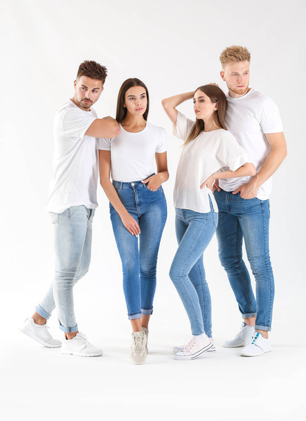 Fiatalok csoportja stílusos alkalmi ruhába, fehér háttéren - Fotó, kép