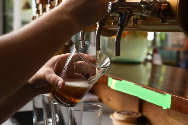 Μπάρμαν ρίχνει φρέσκια μπύρα σε γυαλί, κοντινό πλάνο - Φωτογραφία, εικόνα
