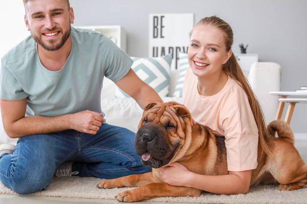 自宅でかわいい犬と幸せなカップル - 写真・画像