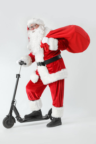 Papai Noel com scooter e presentes no fundo branco
 - Foto, Imagem