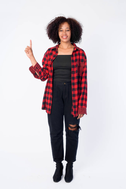 Full body shot of happy young beautiful African hipster woman pointing up - Photo, image