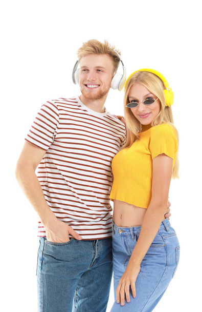 Young couple listening to music on white background - Foto, Imagen