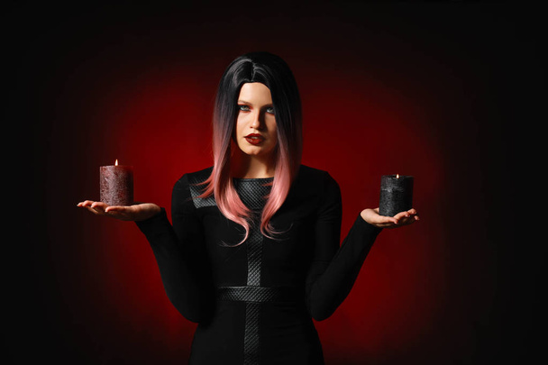Beautiful woman with candles dressed for Halloween on dark background - Fotografie, Obrázek
