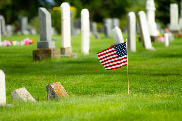 Bandeira acenando no cemitério durante o dia comemorativo
 - Foto, Imagem