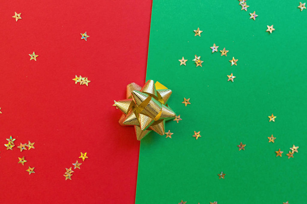 Świąteczna kompozycja. czerwone i zielone tło ze złotym konfetti. koncepcji nowego roku. Kartki okolicznościowe, uroczystości świąteczne 2020. Płaski lay, widok z góry, przestrzeń kopiowania, makieta - Zdjęcie, obraz