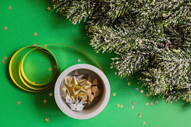 bandes d'emballage de Noël et branches de sapin sur fond vert avec confettis. nouvelle année concept. Carte de voeux, célébration de Noël 2020. Pose plate, gabarit, vue du dessus
 - Photo, image