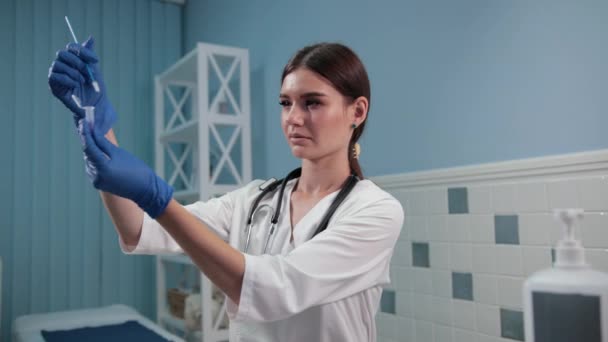 nurse doctor holding a test tube, carefully examines it - Video
