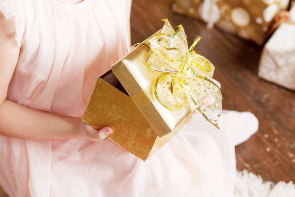 Child's  hands holding gold gift box. Christmas, hew year, birt - Foto, Imagem