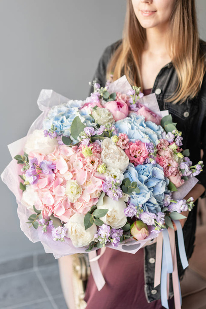 Large Beautiful bouquet of mixed flowers in woman hand. Floral shop concept . Beautiful fresh cut bouquet. Flowers delivery - Foto, immagini