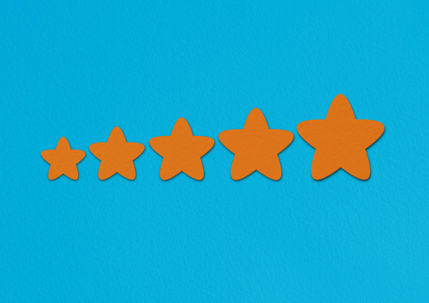 Orange stars rating on a blue background. A conceptual image of a level or achievement. - Фото, изображение