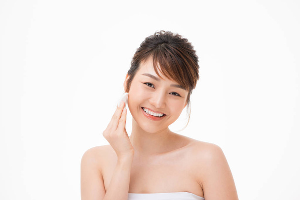 Красота портрет счастливой полуобнаженной азиатской женщины, удаляющей макияж с помощью ваты
 - Фото, изображение