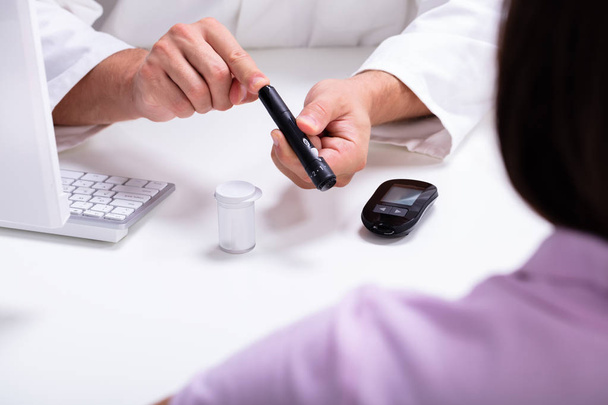 Doctor Showing Lancet Pen And Digital Glucometer To Woman For Checking Blood Sugar Level - Fotoğraf, Görsel