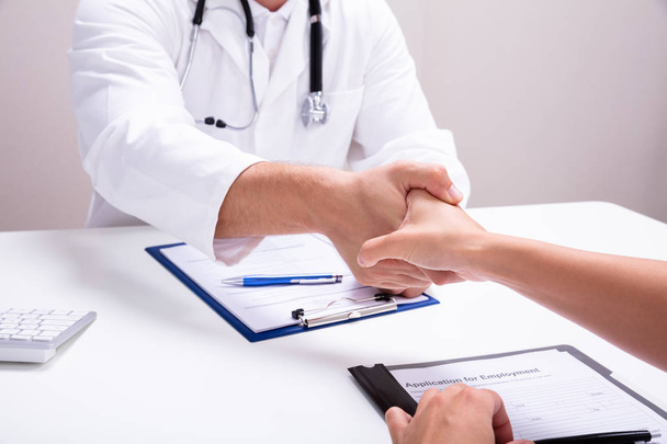 Male Doctor Shaking Hands With Female Nurse In Clinic - Photo, image