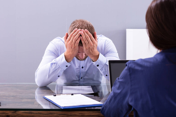 Stressed Young Business Man Holding His Head At Interview In Office - Foto, afbeelding