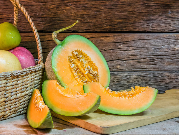 The closeup image of Cantaloupe melon slices on a wooden plate w - Foto, Bild
