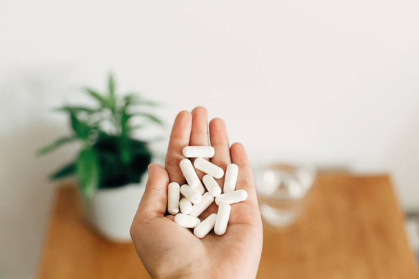 White pills. Dietary supplements.Hand holding magnesium capsules - Photo, Image
