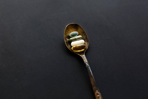Omega 3, spirulina, chlorophyll, magnesium capsules on spoon on  - Fotografie, Obrázek