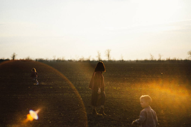 happy family is walking along the wheat field at sunset. The concept of family and love. - Fotó, kép