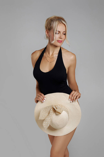 slim woman blonde in black bodysuit with straw hat - Foto, afbeelding