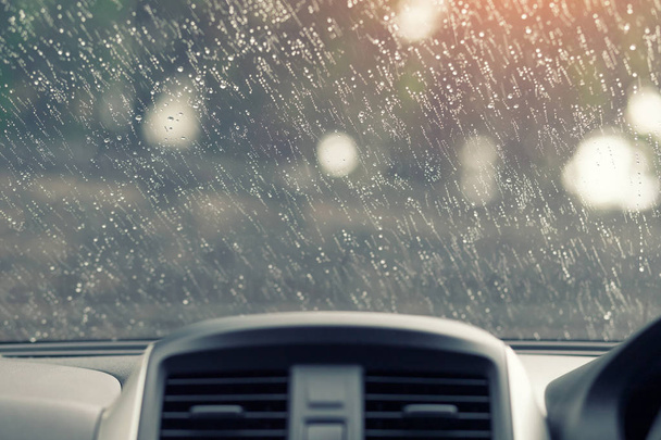 Капли дождя на лобовое стекло Вид изнутри автомобиля, консольная зона мягкий солнечный свет
. - Фото, изображение