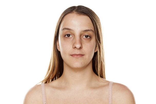 Jonge vrouw zonder make-up op witte achtergrond - Foto, afbeelding