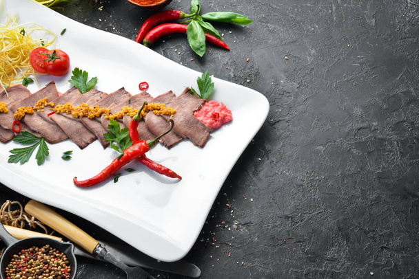 Boiled veal tongue with vegetables and spices on a plate. Restaurant dishes. Top view. Free space for your text. - Фото, зображення