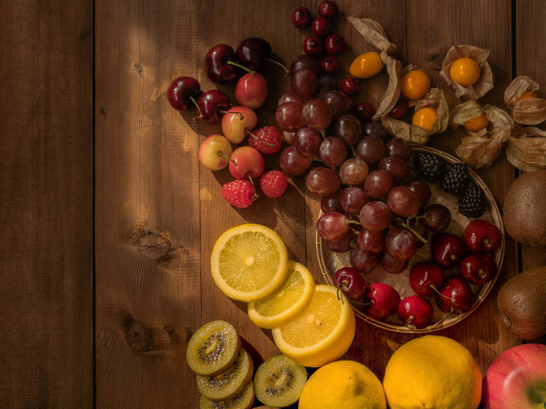 La imagen plana de la naturaleza muerta de las variedades de frutas en t de madera
 - Foto, imagen