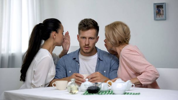 Wife and mother-in law in quarrel whispering man on ear, family confrontation - Foto, Imagem