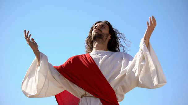 Jesus raising hands to sky and praying, resurrection and ascension of Christ - 写真・画像