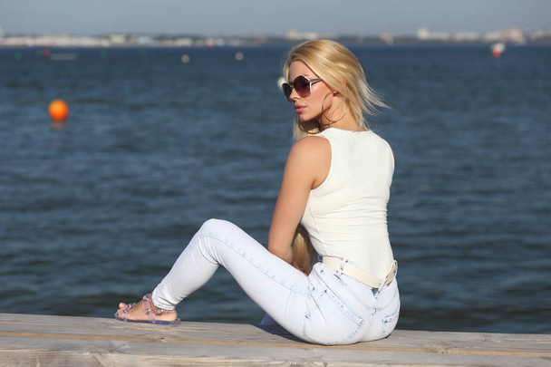 jong stijlvol meisje in lichte jeans en een tanktop - Foto, afbeelding