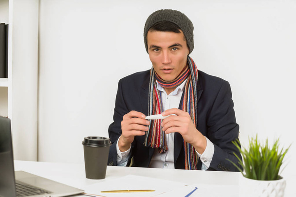 帽子、スカーフ、ジャケットを着たアジア人男性が温度ウィットを測定 - 写真・画像