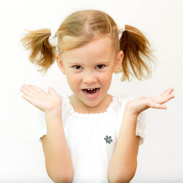Cheerful smiling little girl at the white background. School con - 写真・画像