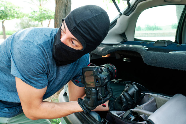 злодій з крадіжкою обладнання для фотозйомки та об'єктивів з автомобіля - Страхова та юридична концепція
 - Фото, зображення