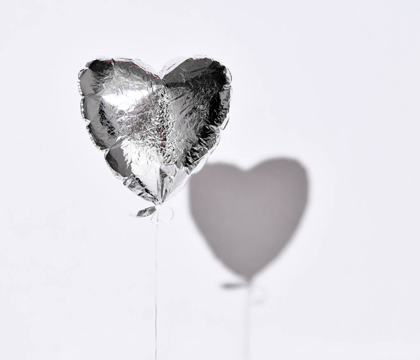 Party is over deflated silver heart balloon object  on white gray background with shadow - Zdjęcie, obraz