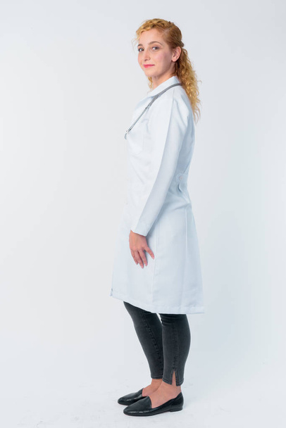 Full body shot profile view of blonde woman doctor looking at camera - Fotografie, Obrázek