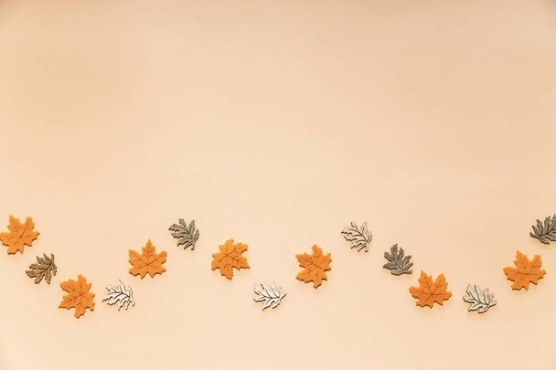 Золотые листья на бежевом фоне. Осень, осенняя концепция
. - Фото, изображение